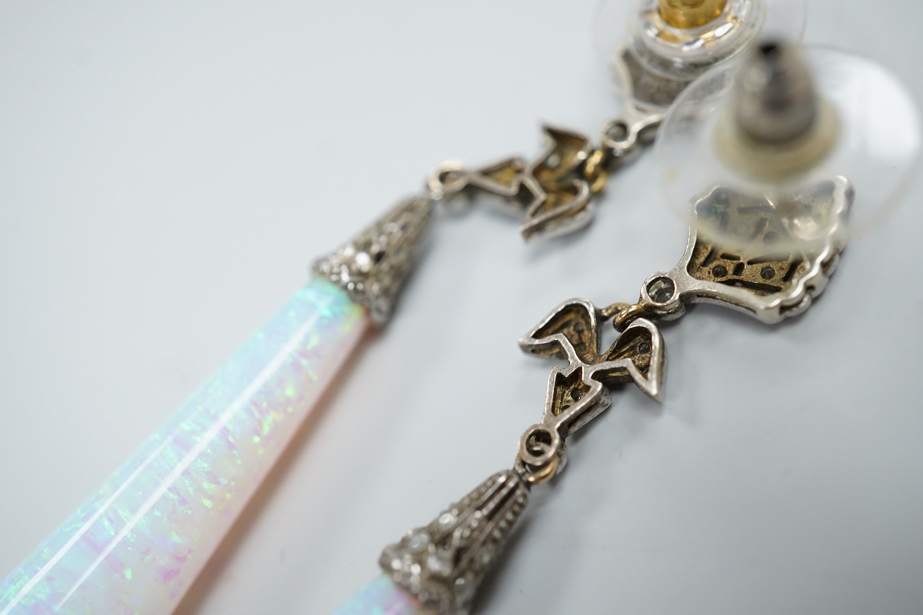A pair of 1920's style white metal, synthetic opal and diamond chip set drop earrings, 63mm, gross weight 8.2 grams.
